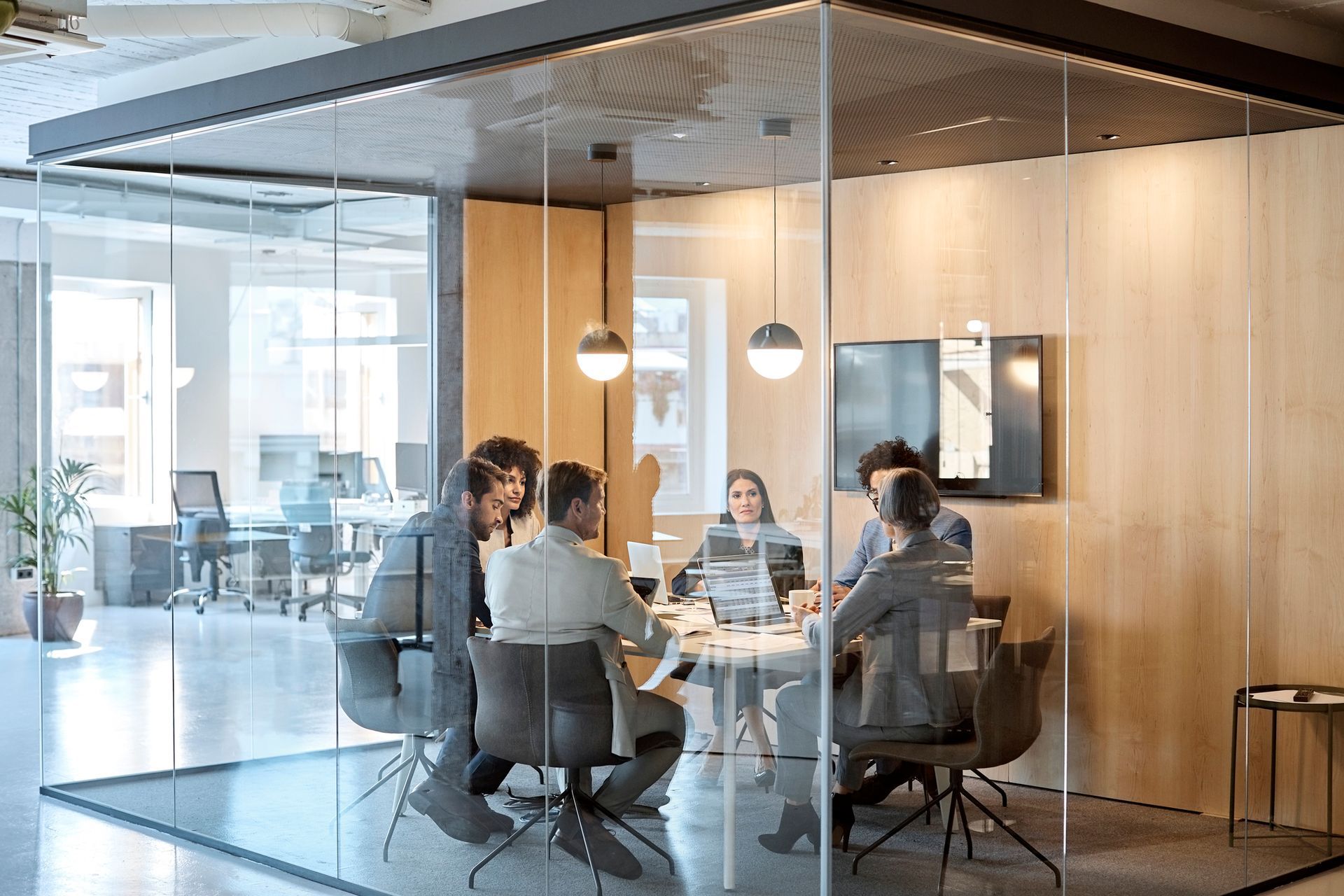 A group of people are sitting around a table in a conference room.