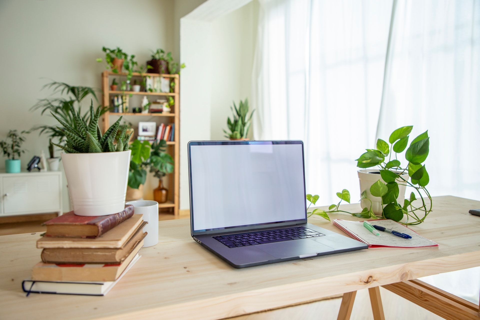 A laptop computer is sitting on a wooden desk in a living room.