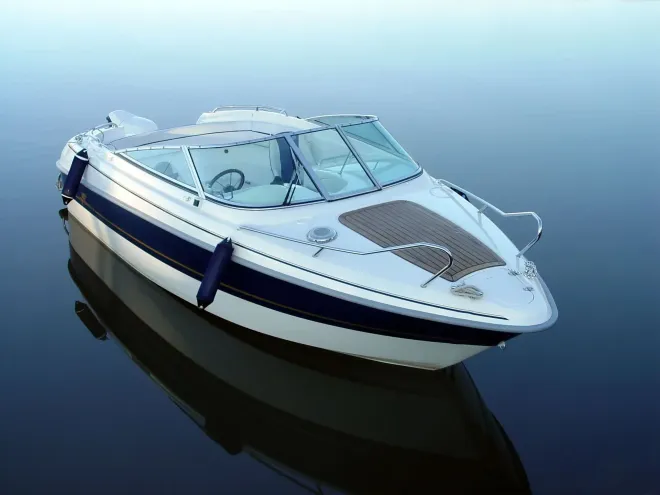 A white and blue boat is floating on top of a body of water