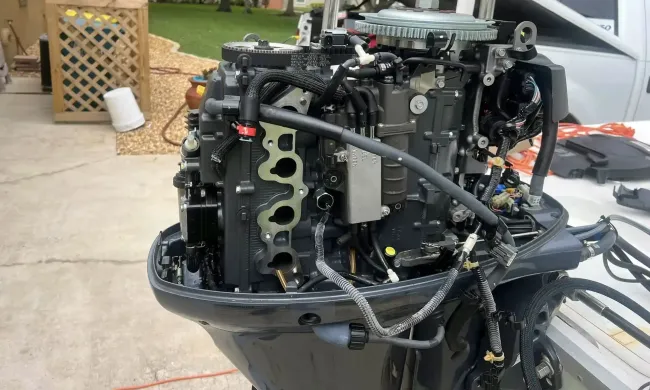 The engine of a boat is sitting on the ground.