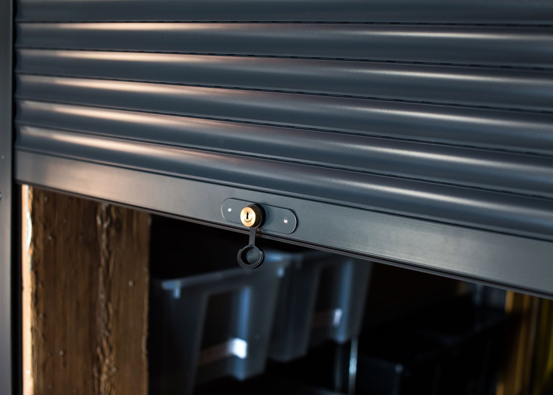 Dark gray rolling shutter with a key lock, partially closed.