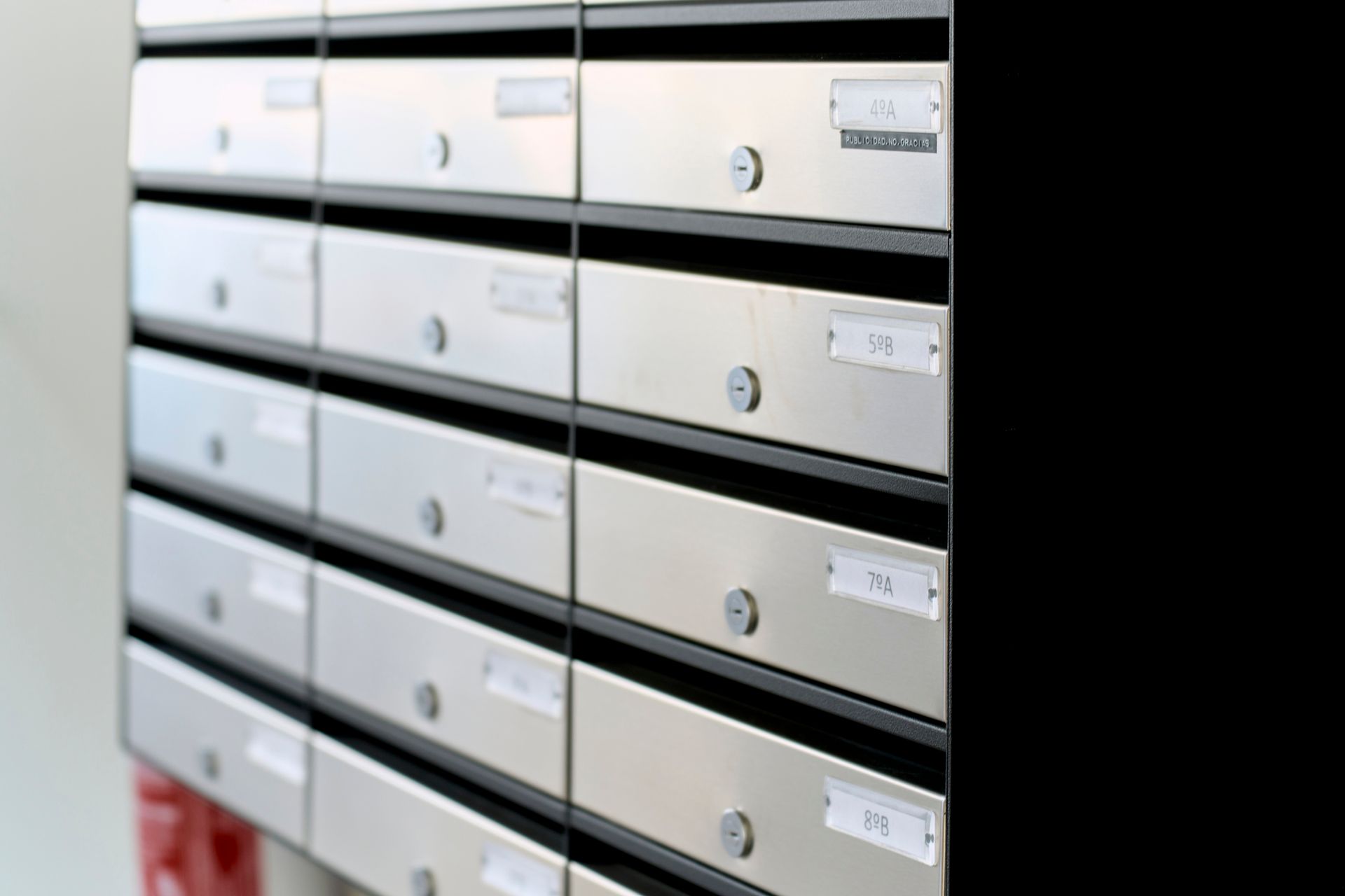 Rows of silver mailboxes with small address labels.