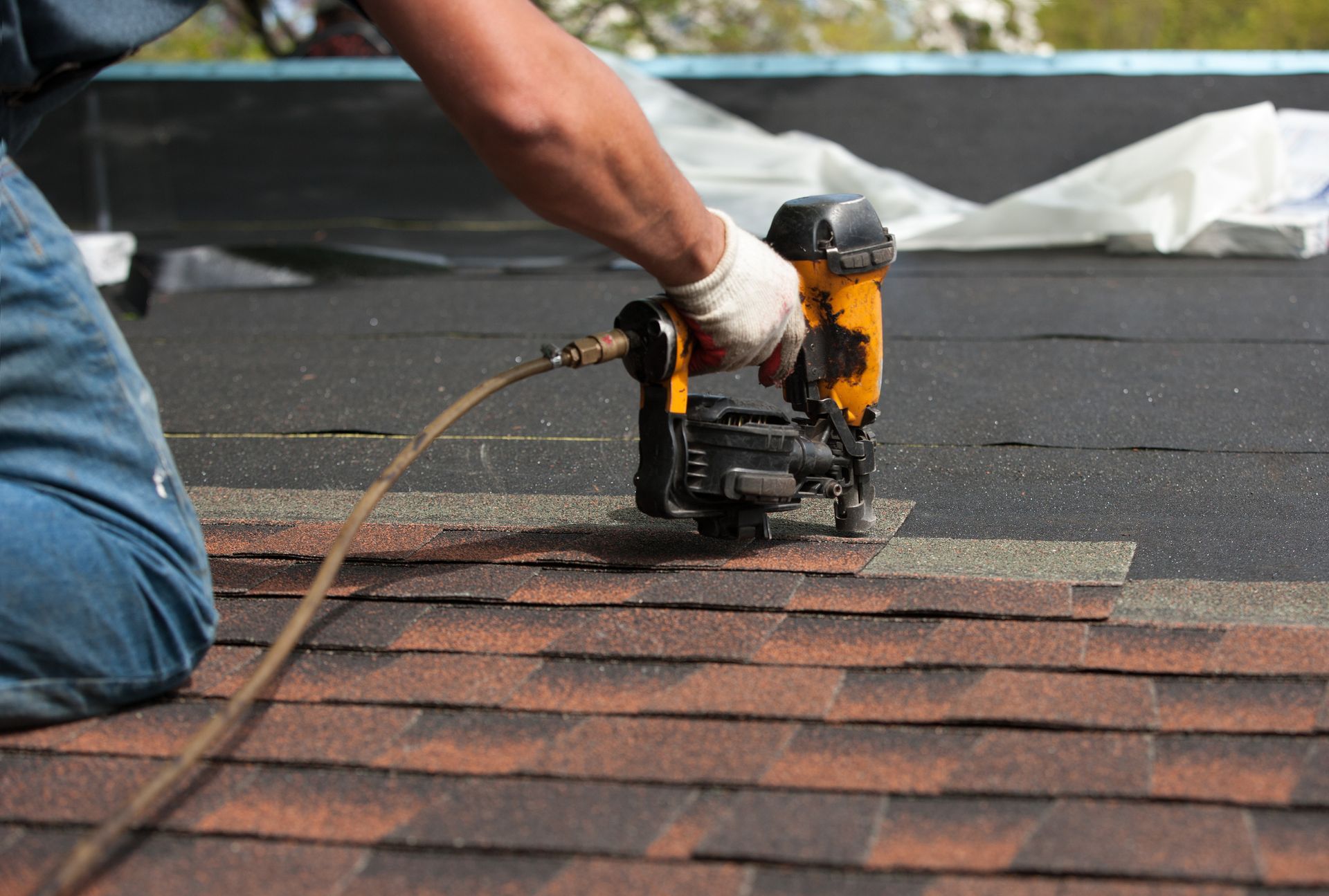 Roofing contractors installing shingle roof on new house.