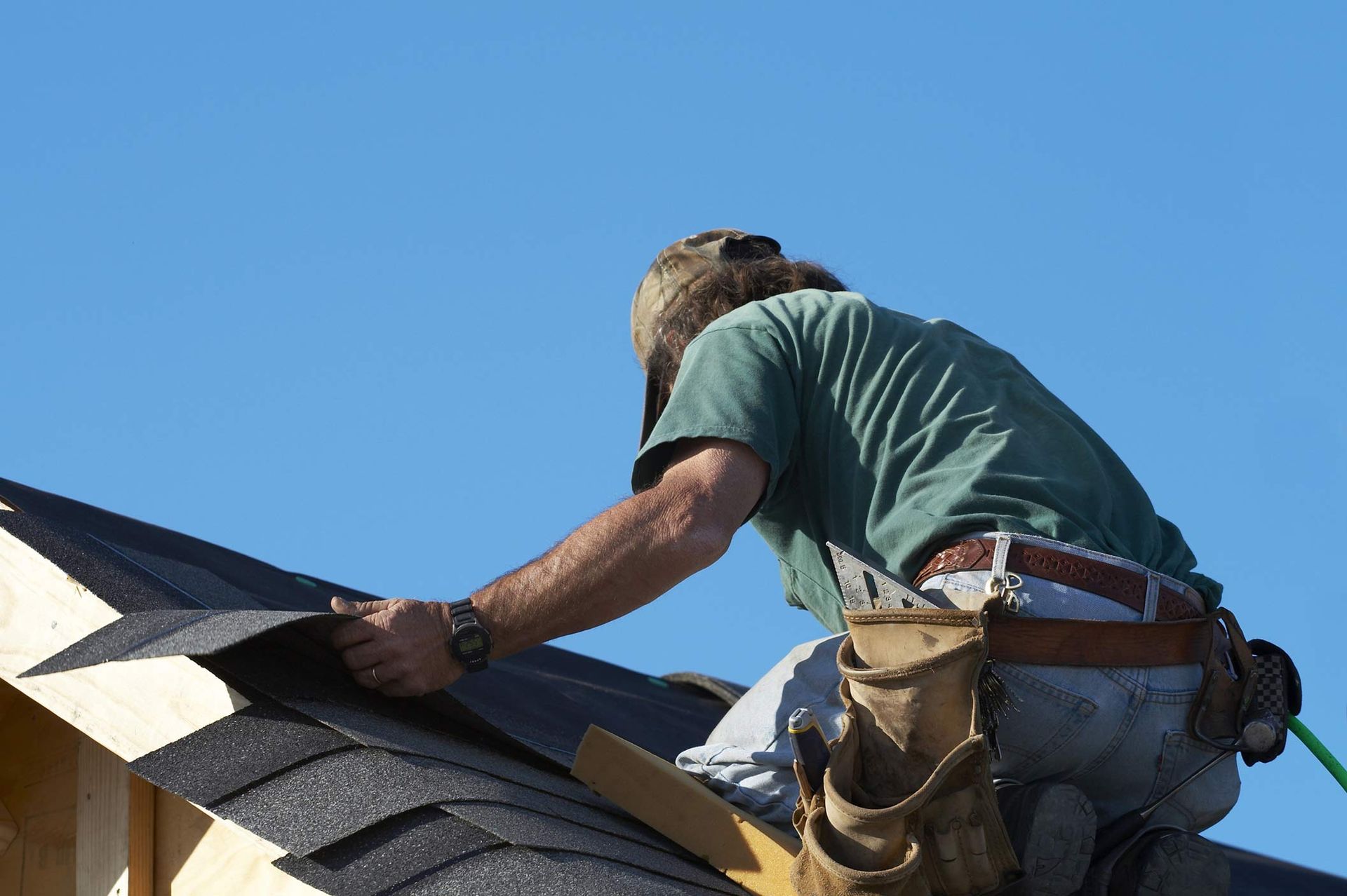Roof contractor on a steep roof performing professional roofing services.
