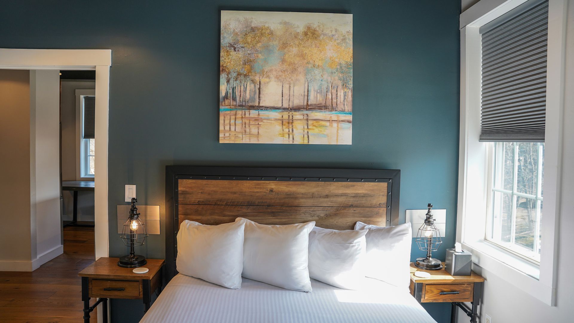 There is a painting on the wall above the bed in the bedroom.