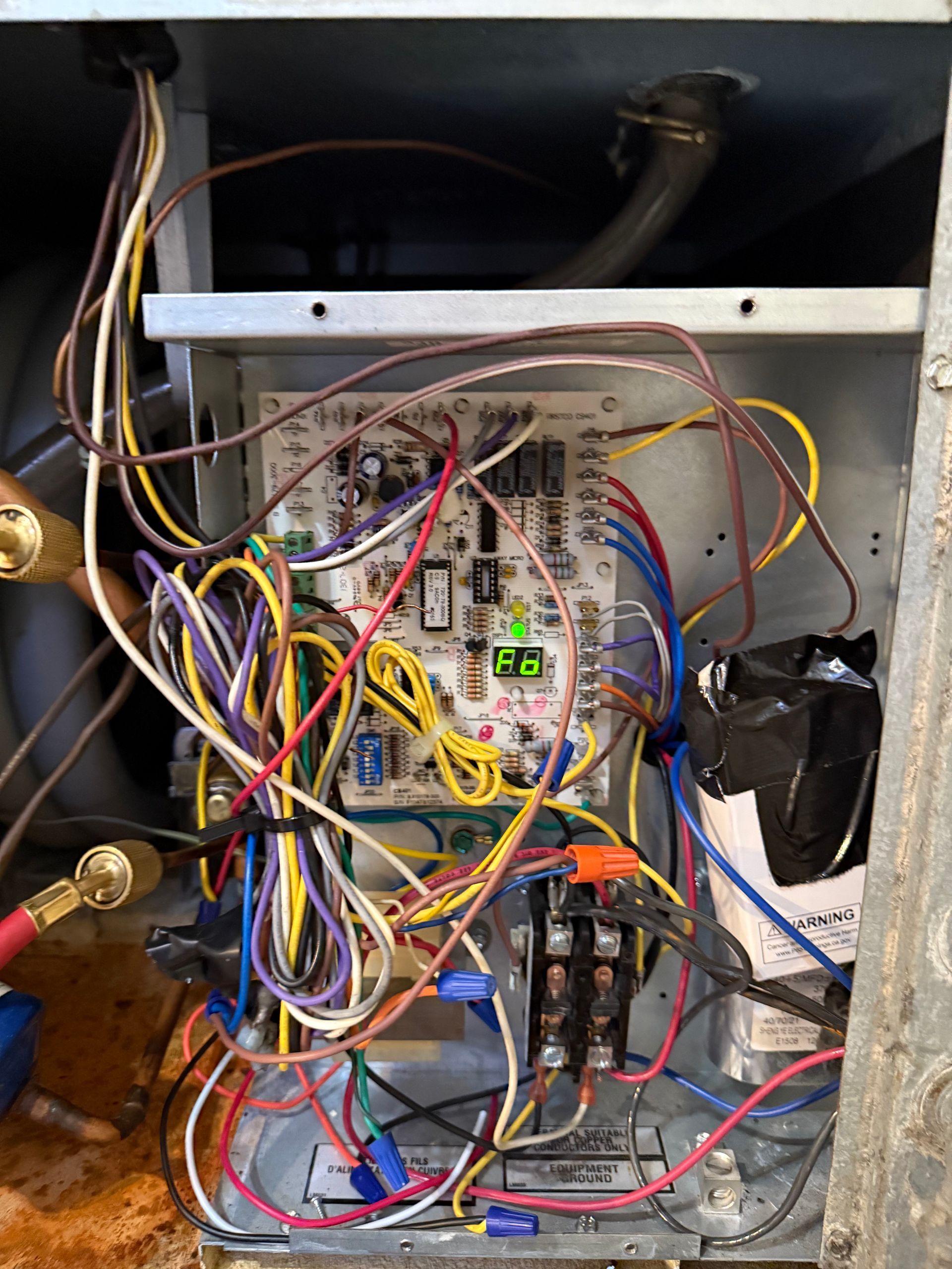 Open electrical panel of an HVAC furnace with a circuit board displaying error code 
