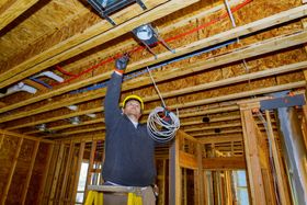 a man is working on the ceiling of a house under construction .