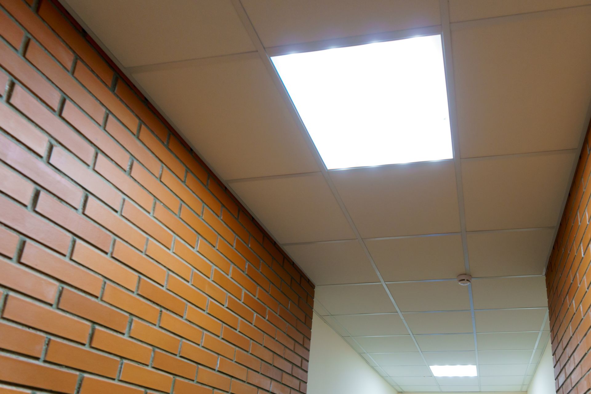 Hallway ceiling with bright square LED panel light.