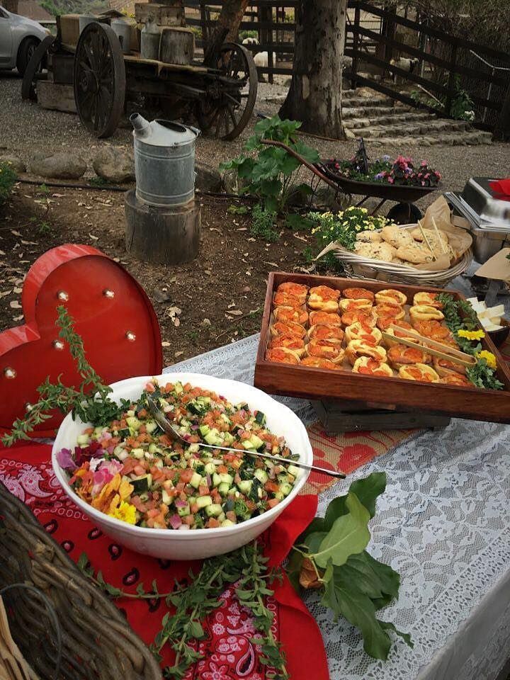 A table with a bowl of salad and a tray of food on it.