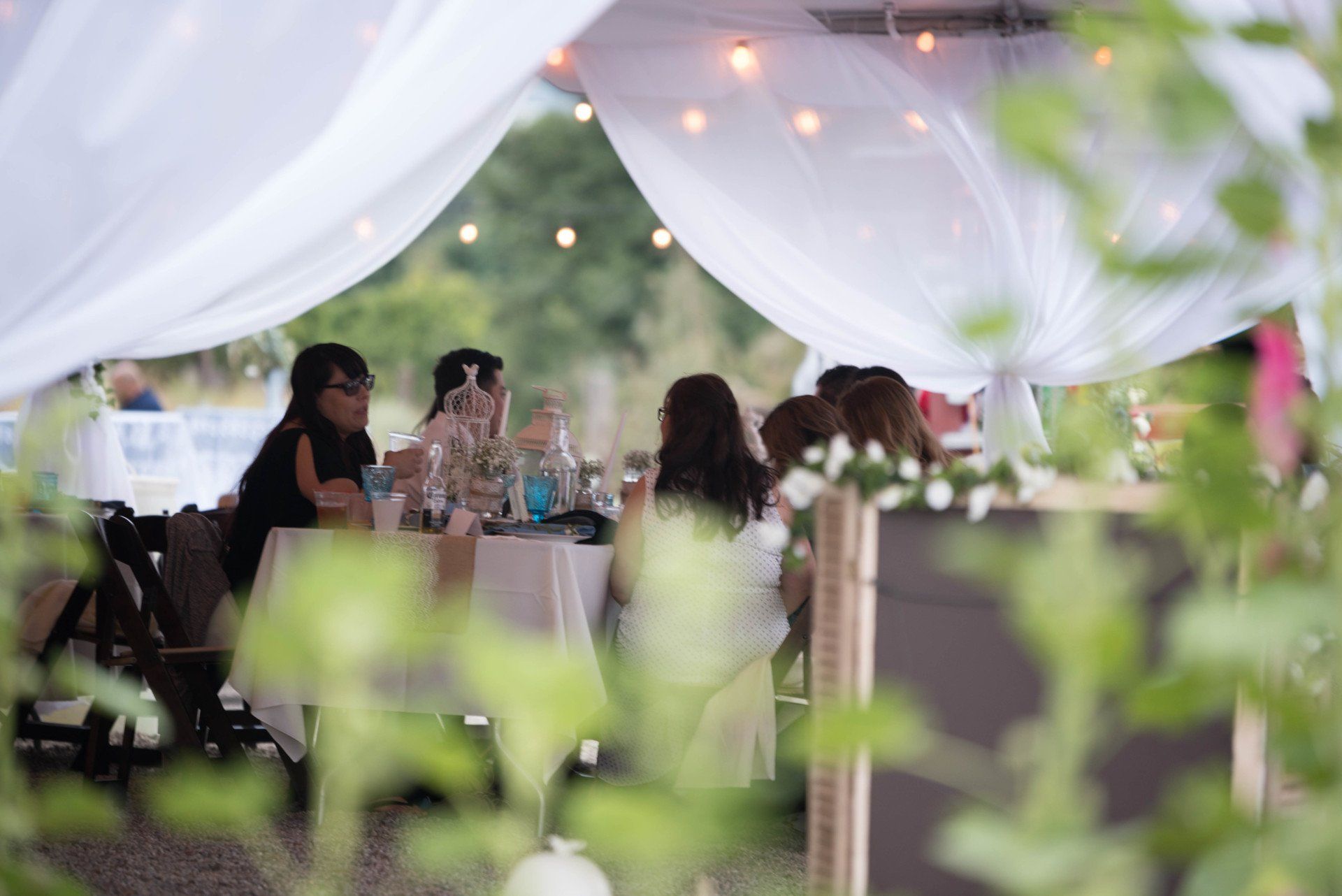 A group of people are sitting at a table under a tent.