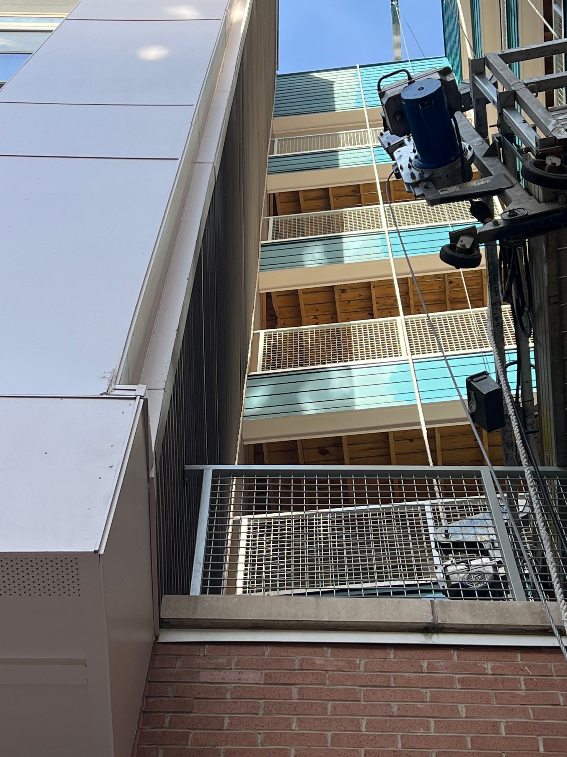 Buildings: brick, light blue and white balconies, and metal framework.