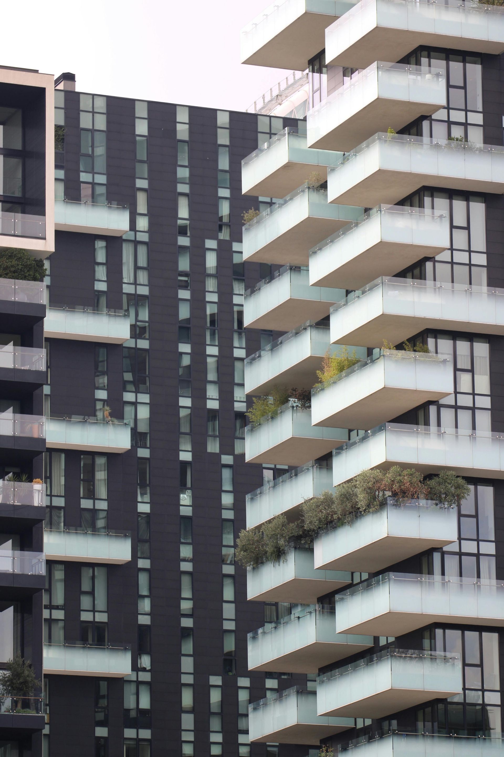 Modern high-rise buildings with white balconies and dark facades.