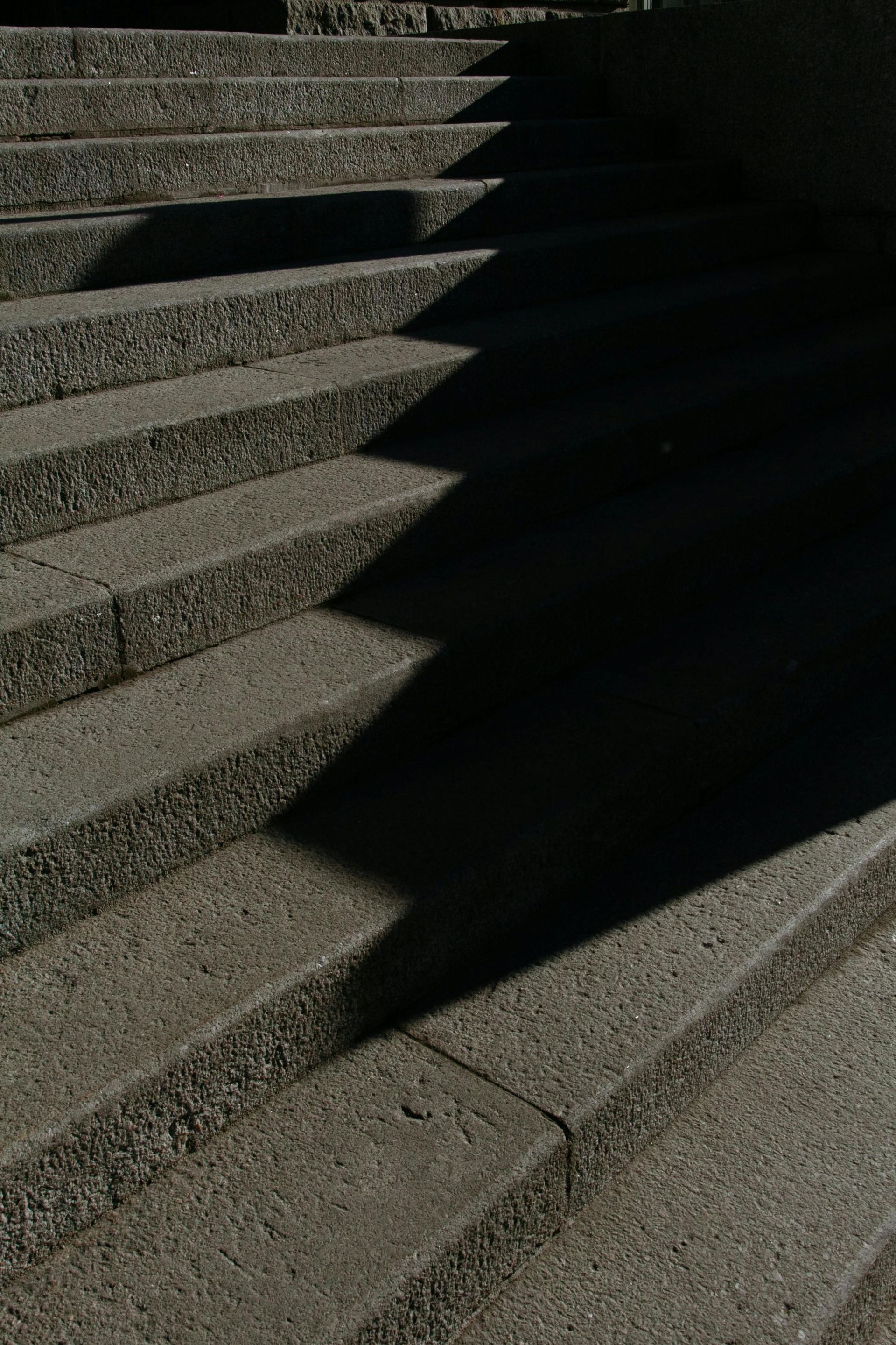 Concrete staircase with harsh diagonal shadows.