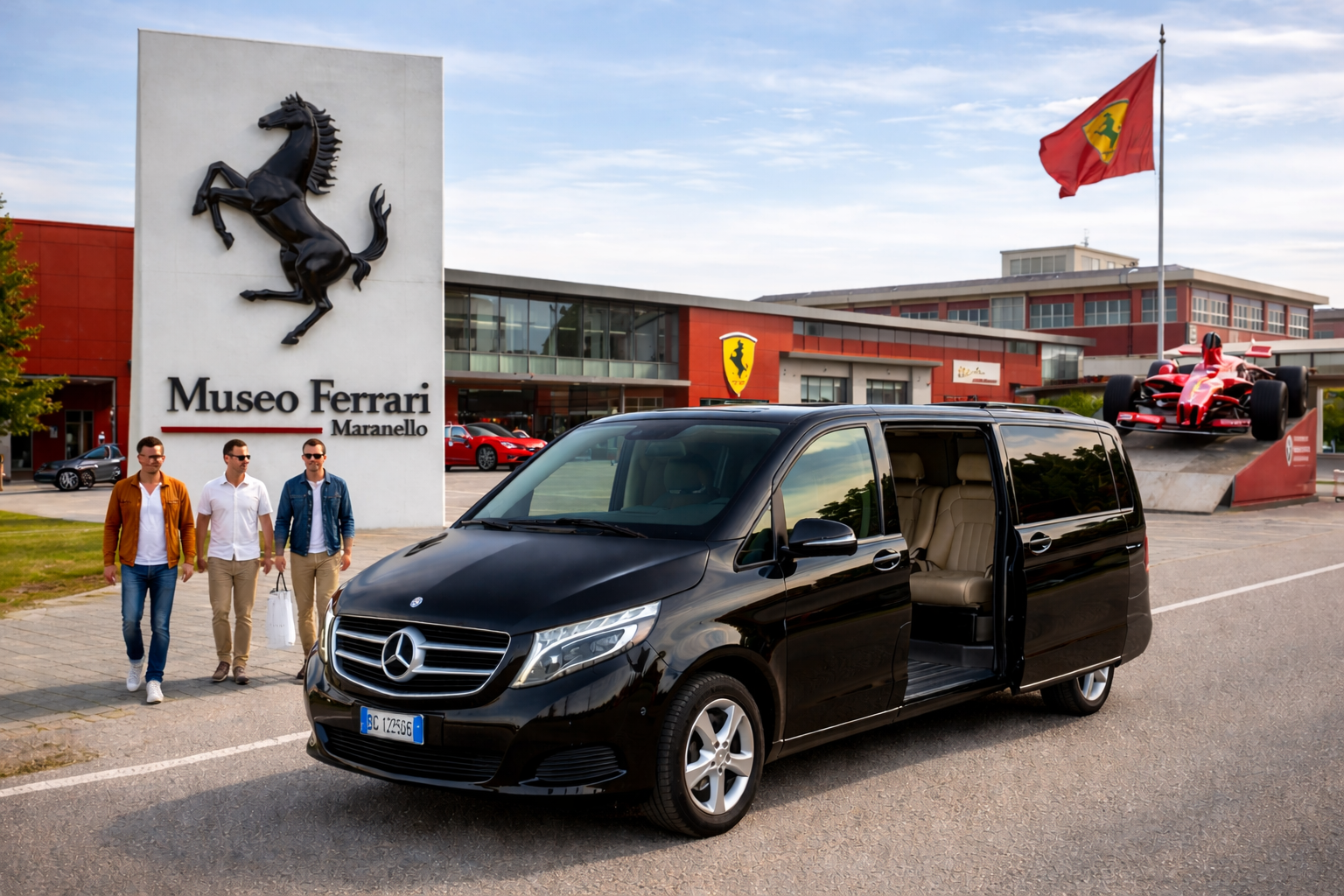 Tre persone passano accanto a un furgone Mercedes nero davanti al Museo Ferrari di Maranello.