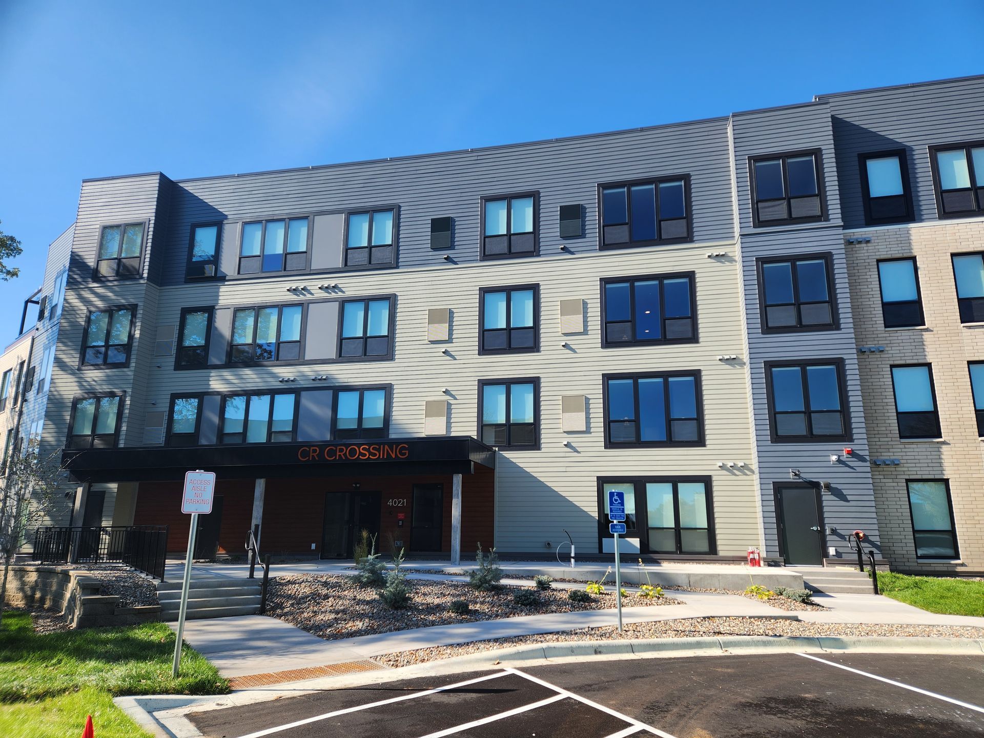 A large building with a lot of windows and a parking lot in front of it