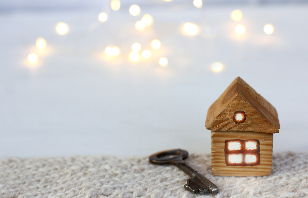 A small wooden house with a key in front of it.