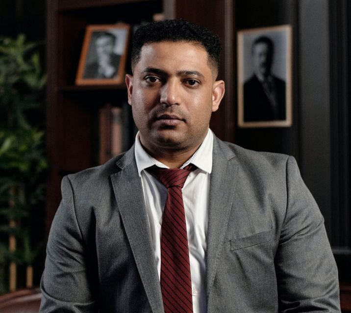 Een man in pak en stropdas poseert voor een foto