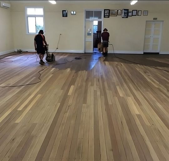 two men polishing the timber floor