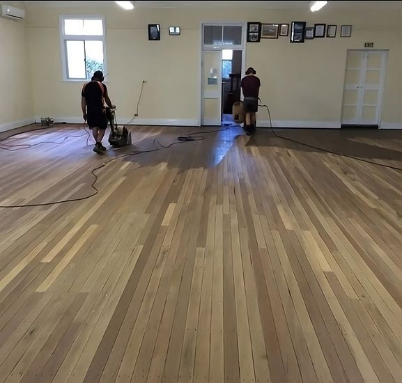 two men polishing the timber floor