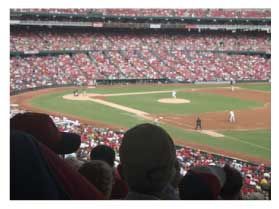 A crowd of people are watching a baseball game in a stadium.