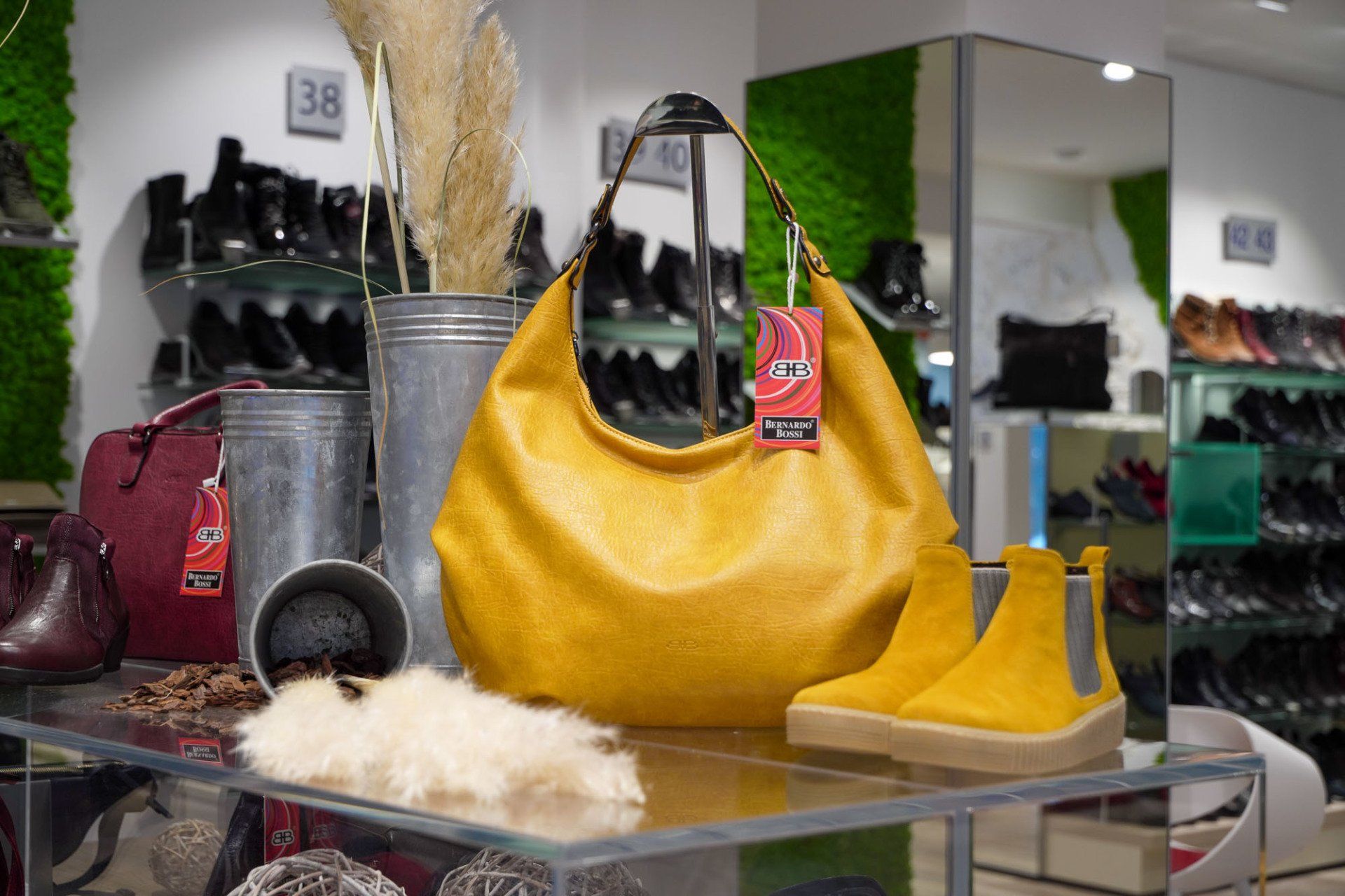 In einem Schuhgeschäft sind eine gelbe Handtasche und gelbe Stiefel ausgestellt.