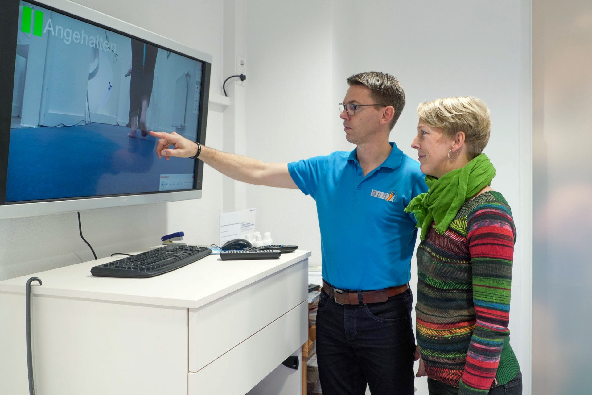 Ein Mann und eine Frau schauen auf einen Computerbildschirm.