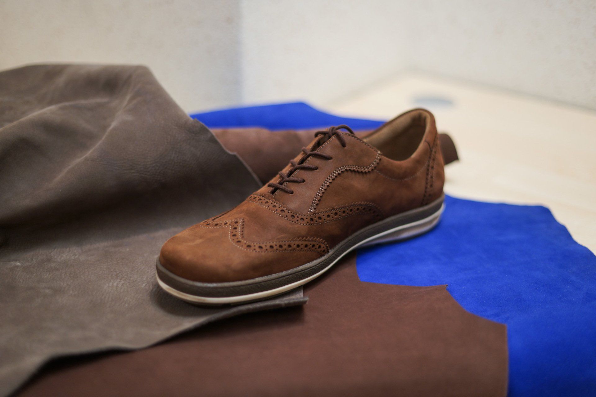 Brauner orthopädischer Maßschuh auf Lederunterlage – handgefertigt für individuelle Fußanpassung