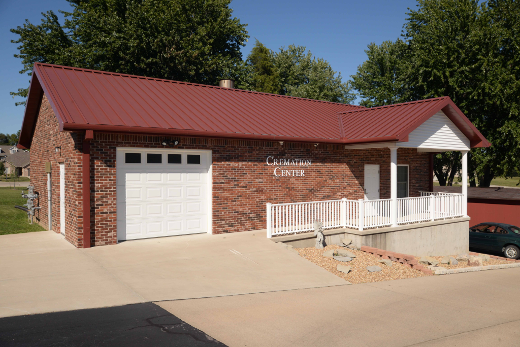 A brick house with a red roof and a white garage door