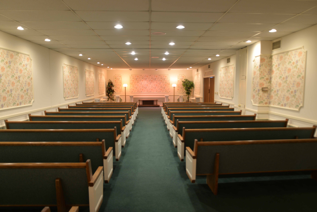There are rows of benches in an empty church.