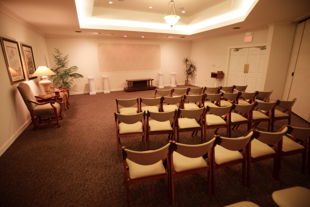 A room with rows of chairs and a fireplace