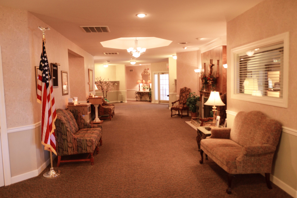 A long hallway with a couch and chairs and an american flag