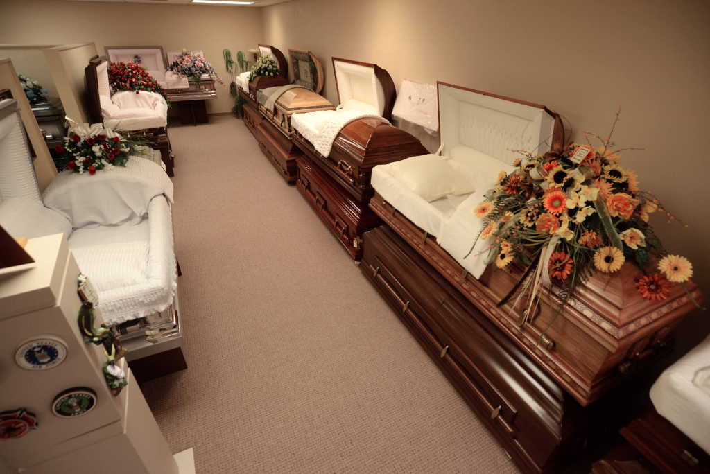 A row of coffins are lined up in a room.