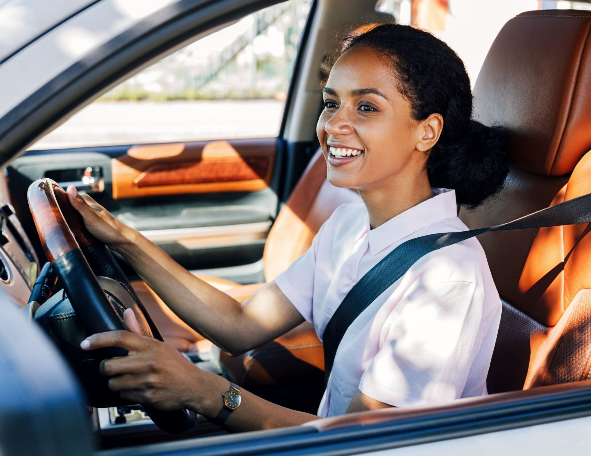A man and a woman are sitting in a car giving a thumbs up.