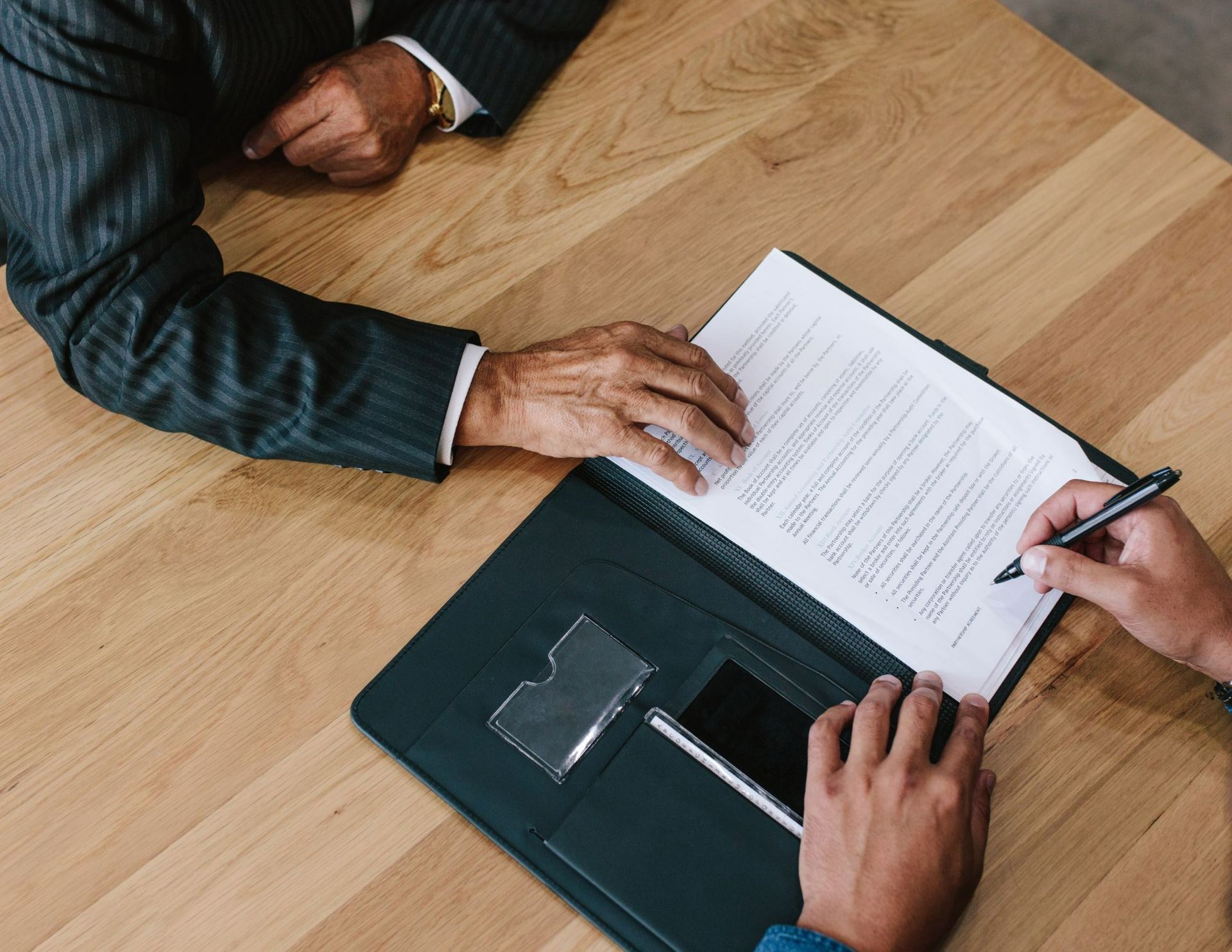 A man and a woman are sitting at a table looking at a piece of paper.