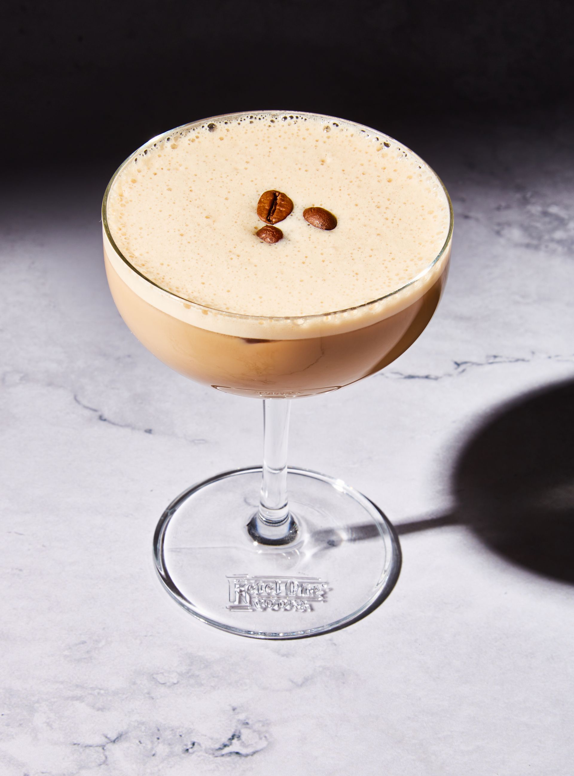 A martini in a wine glass with coffee beans on top