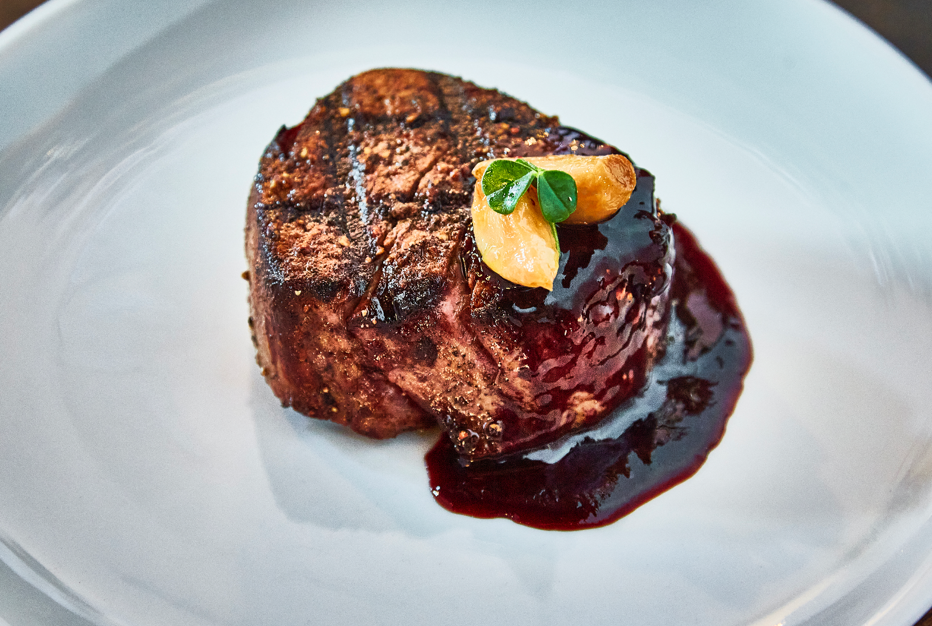 A white plate topped with a steak and rice.