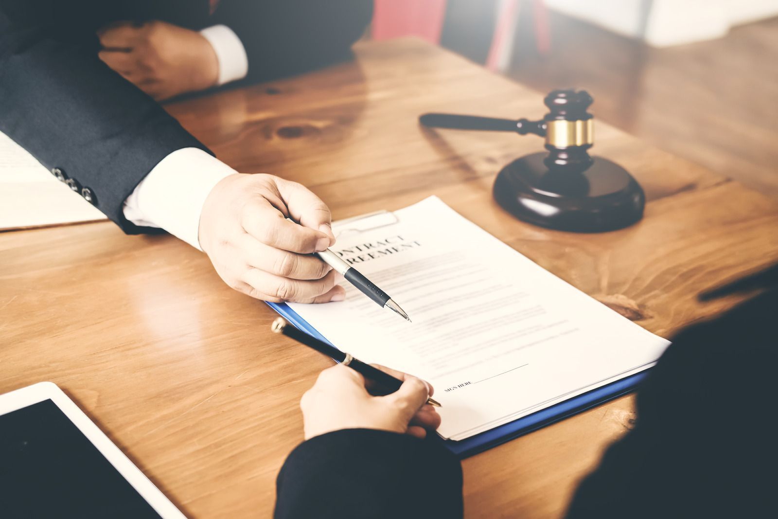 A man and a woman are sitting at a table signing a document.