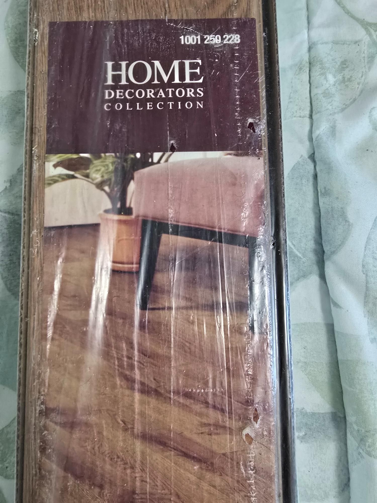 Home Decorators Collection flooring package with a furniture and plant display. Brown tones.