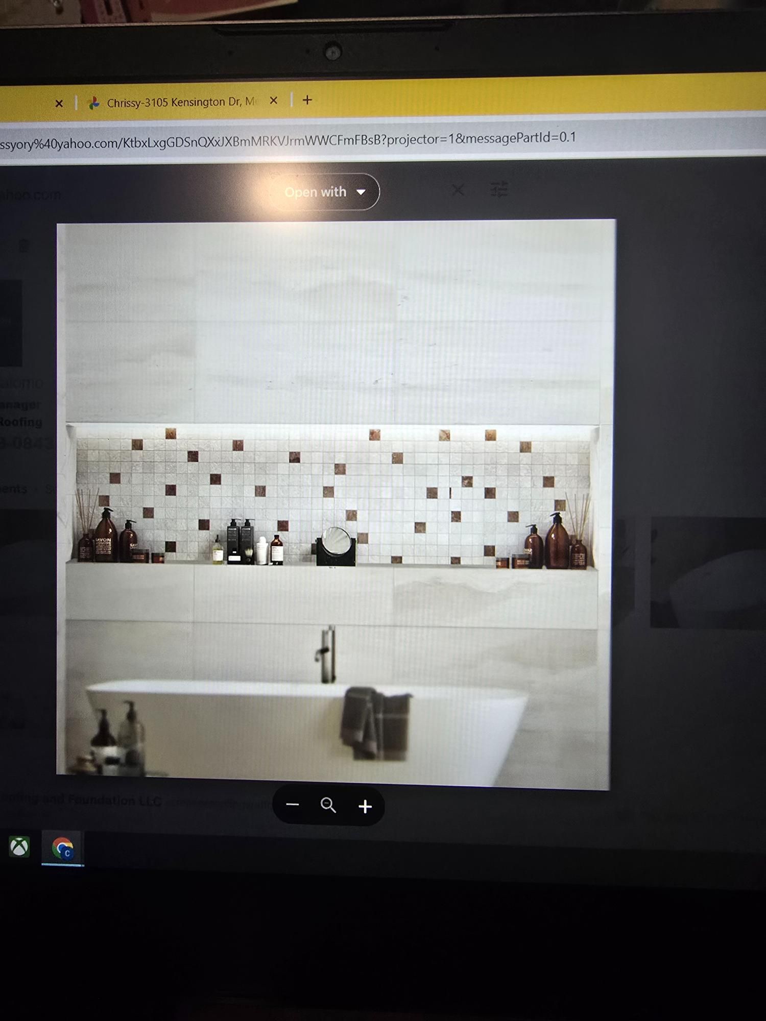 Bathroom with a white bathtub, shelf with toiletries, and decorative tile.