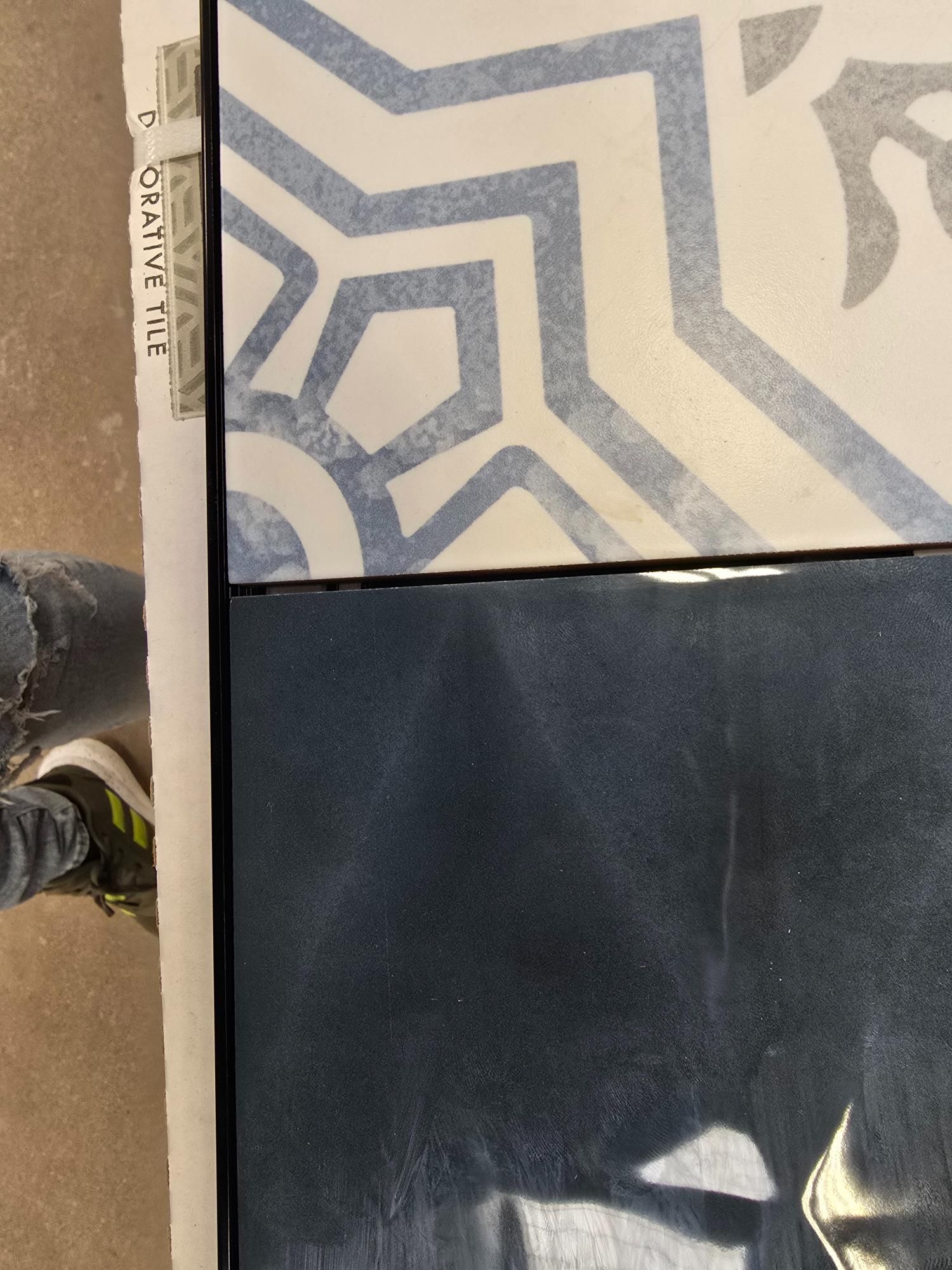 Blue patterned tile next to a dark blue surface.