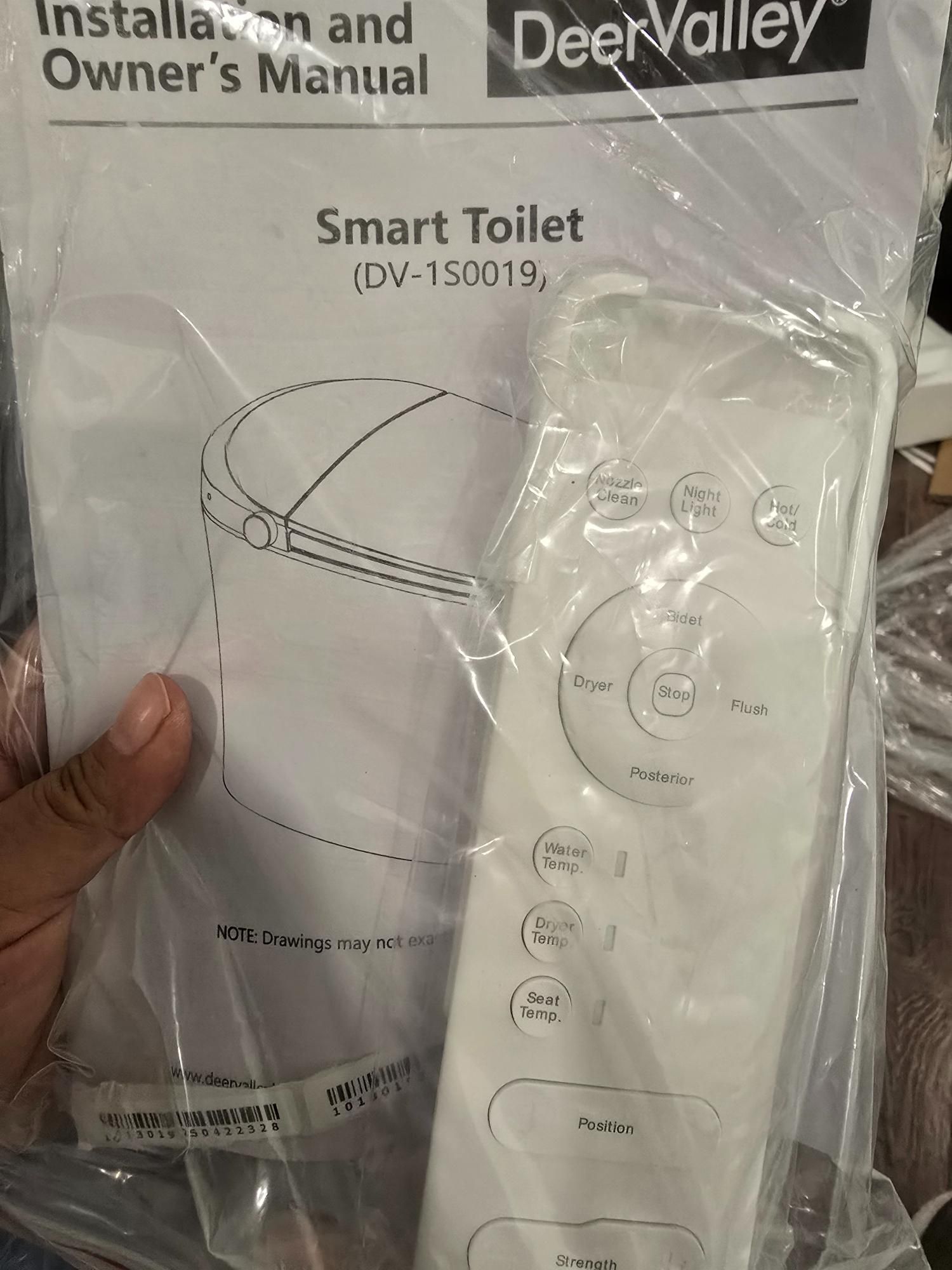 DeerValley Smart Toilet manual and remote control, still in plastic packaging.