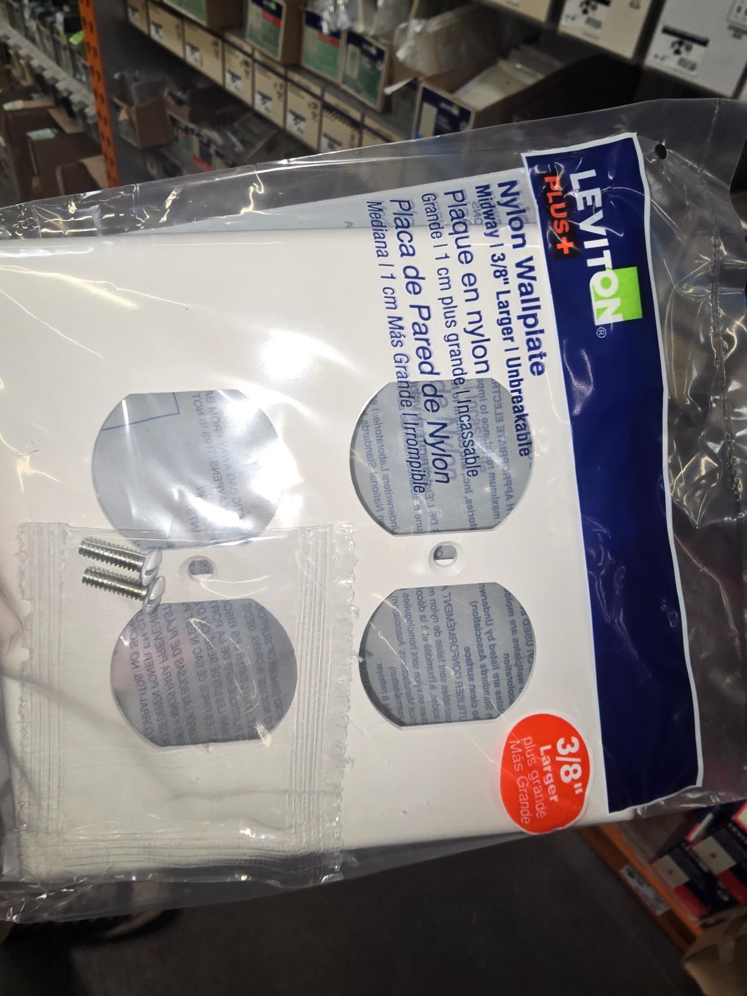 White nylon electrical wallplate in a clear plastic package, with screws.