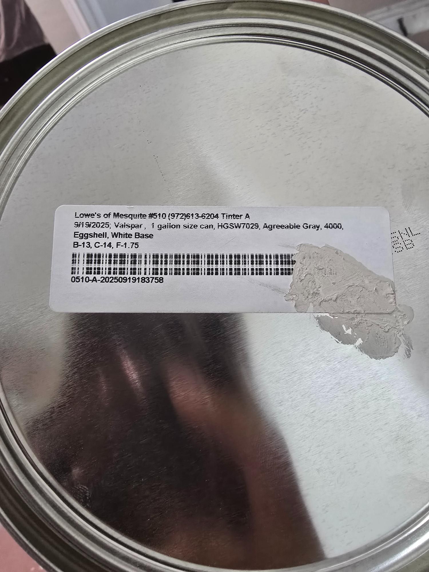 Label on a metal can, with text and a barcode partially obscured by a smudge.