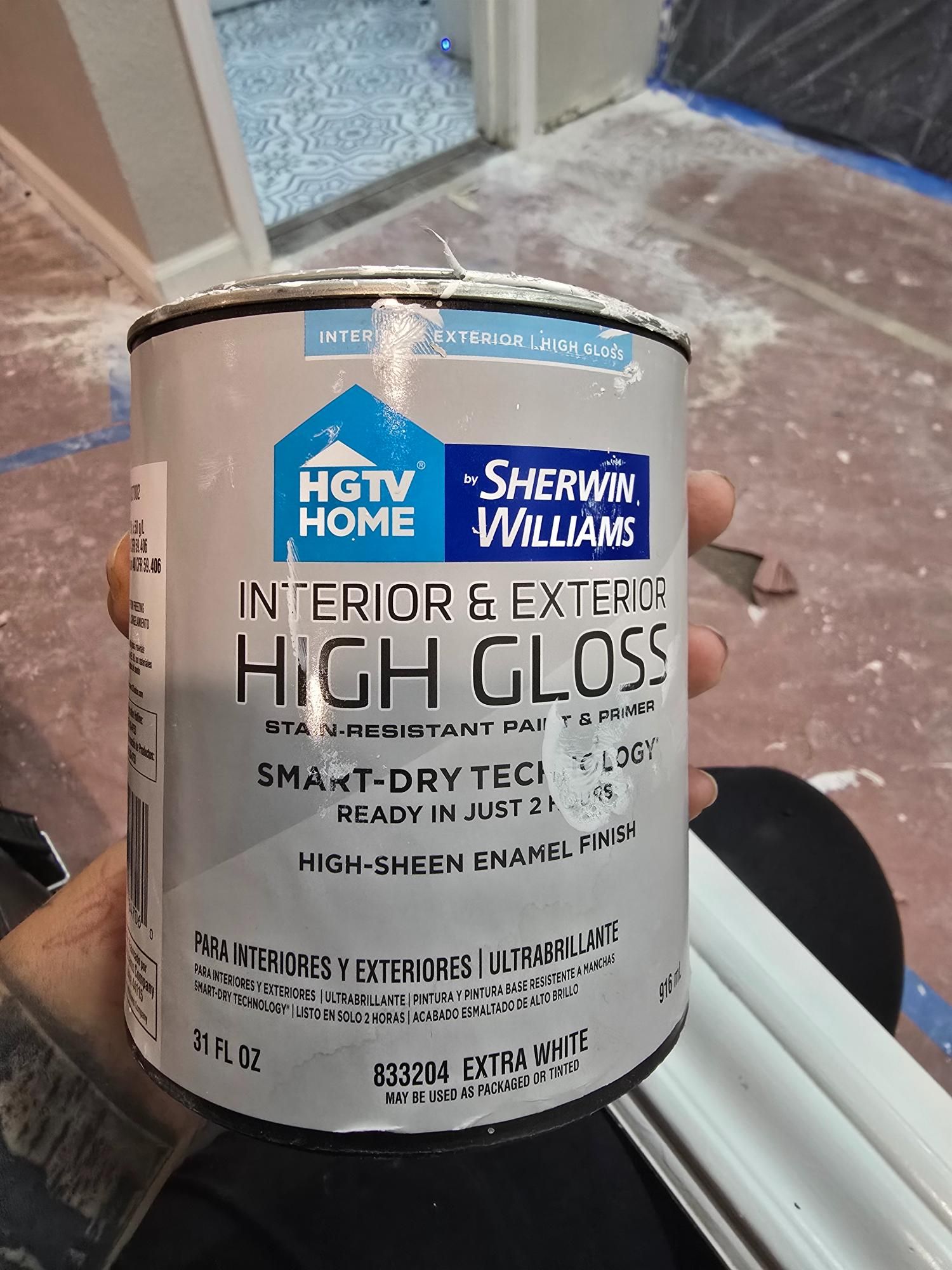 Person holding a can of HGTV Home by Sherwin-Williams high gloss paint, 