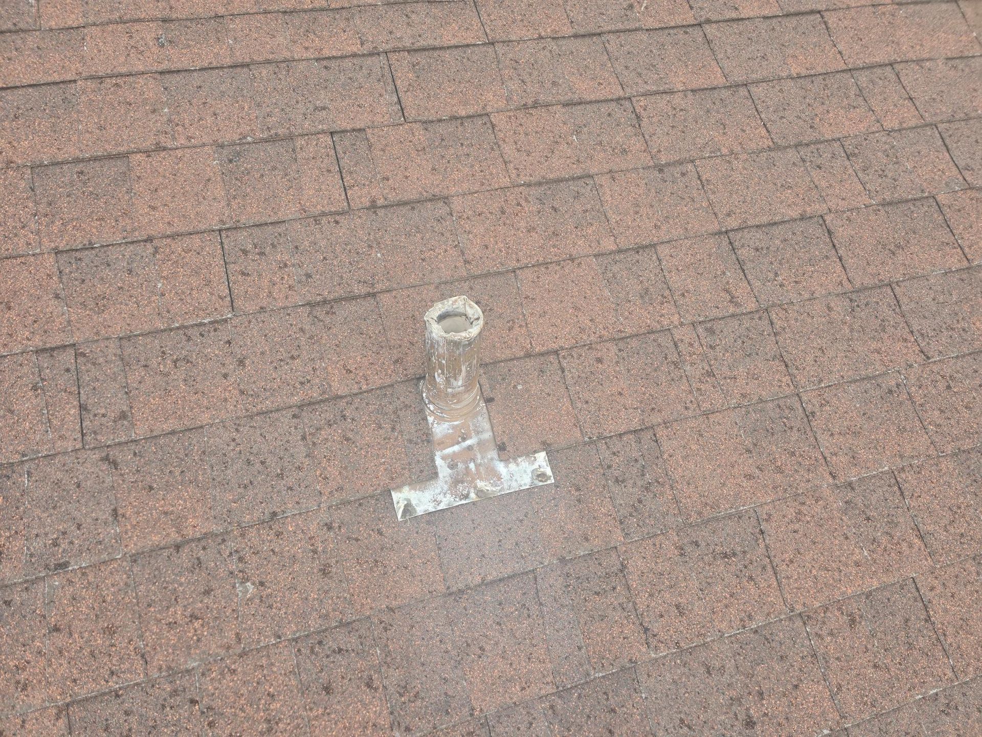 Roof vent on a brown asphalt shingle roof.