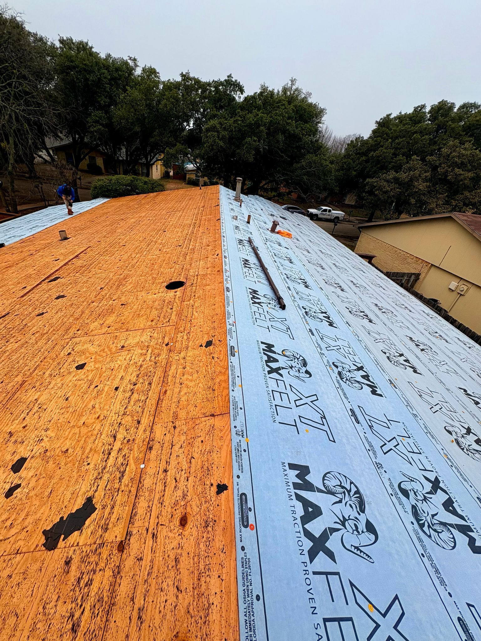Roof with orange and blue insulation boards being installed.