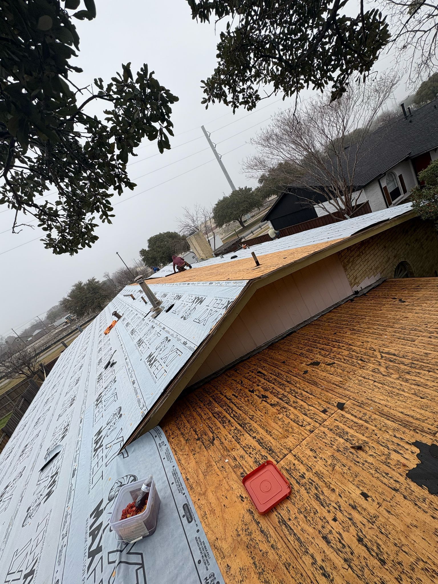 Roof partially covered with sheathing and underlayment; construction site.