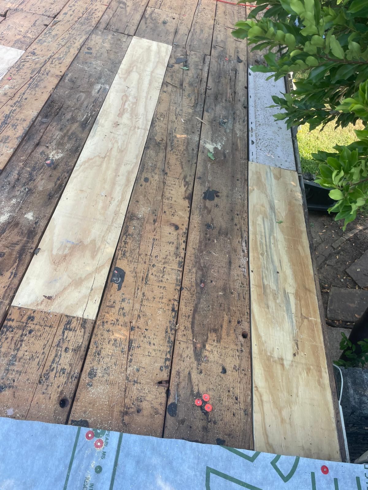 Wooden roof with new plywood sections and roofing membrane.