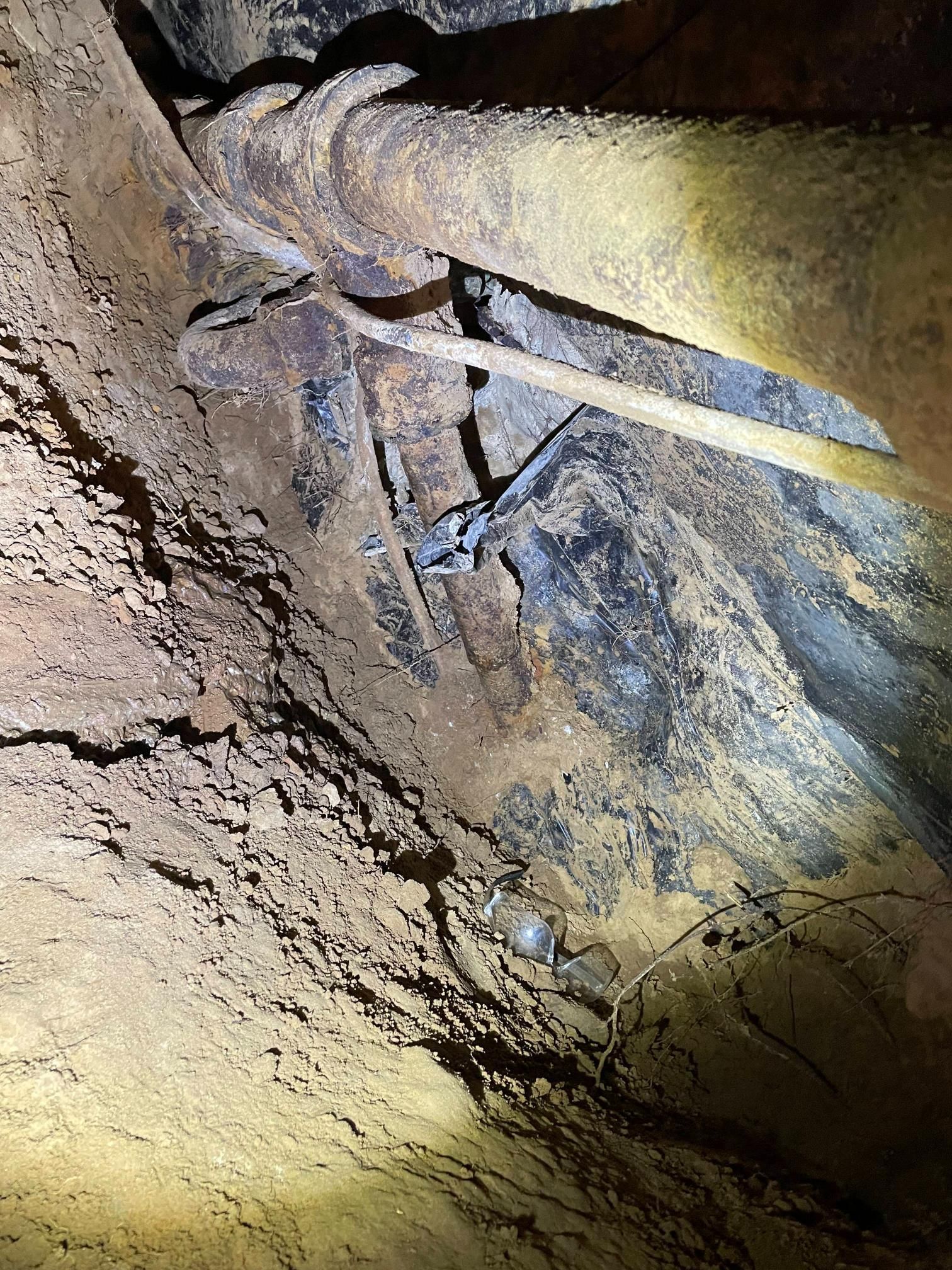 Cave interior with rock formations and metal objects.