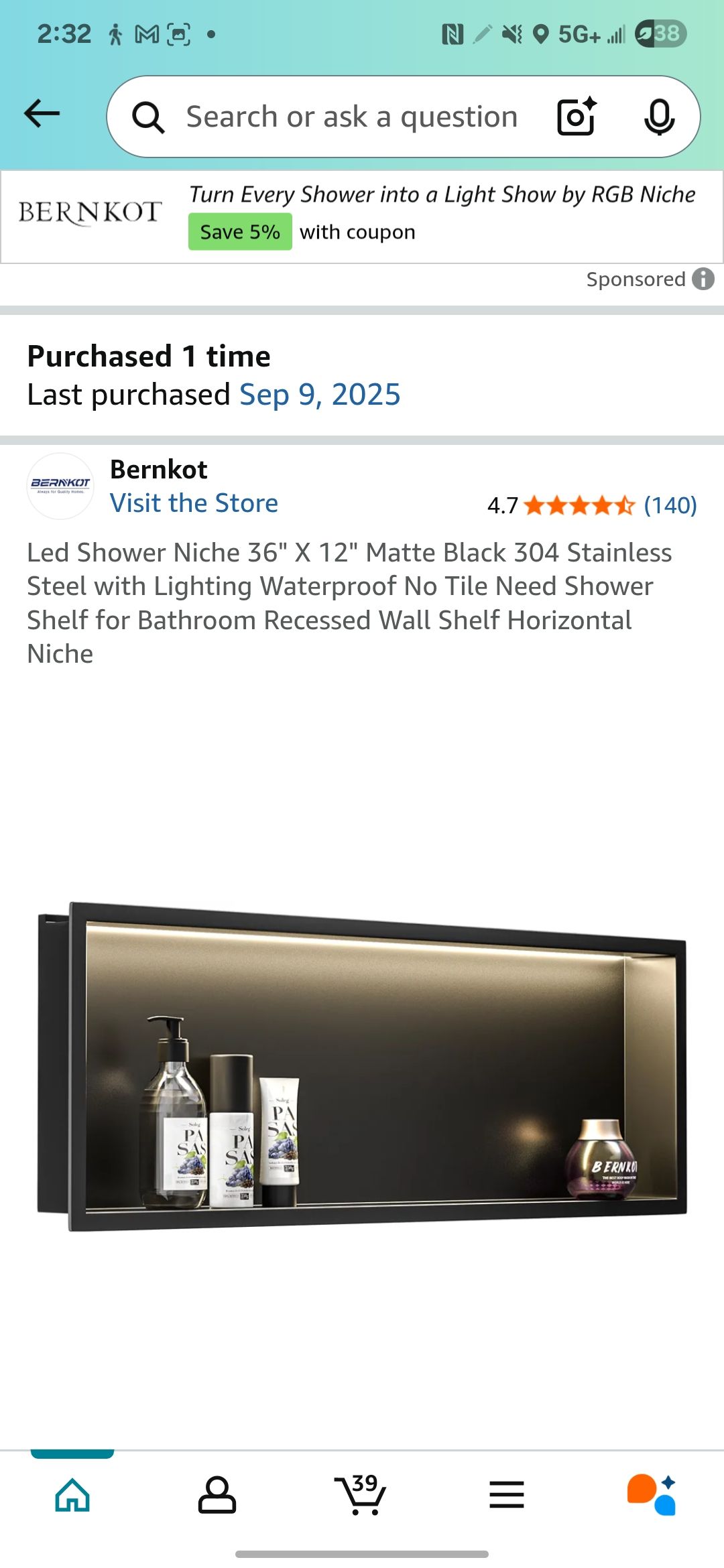 Black rectangular wall shelf with toiletries inside, with a light in the back.